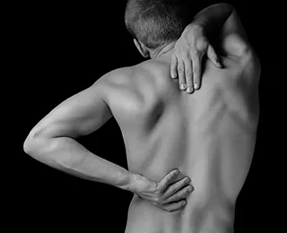 Mann mit schmerzhaften Rückensymptomen: Darstellung von physischem Leid und Heilungsbedarf.